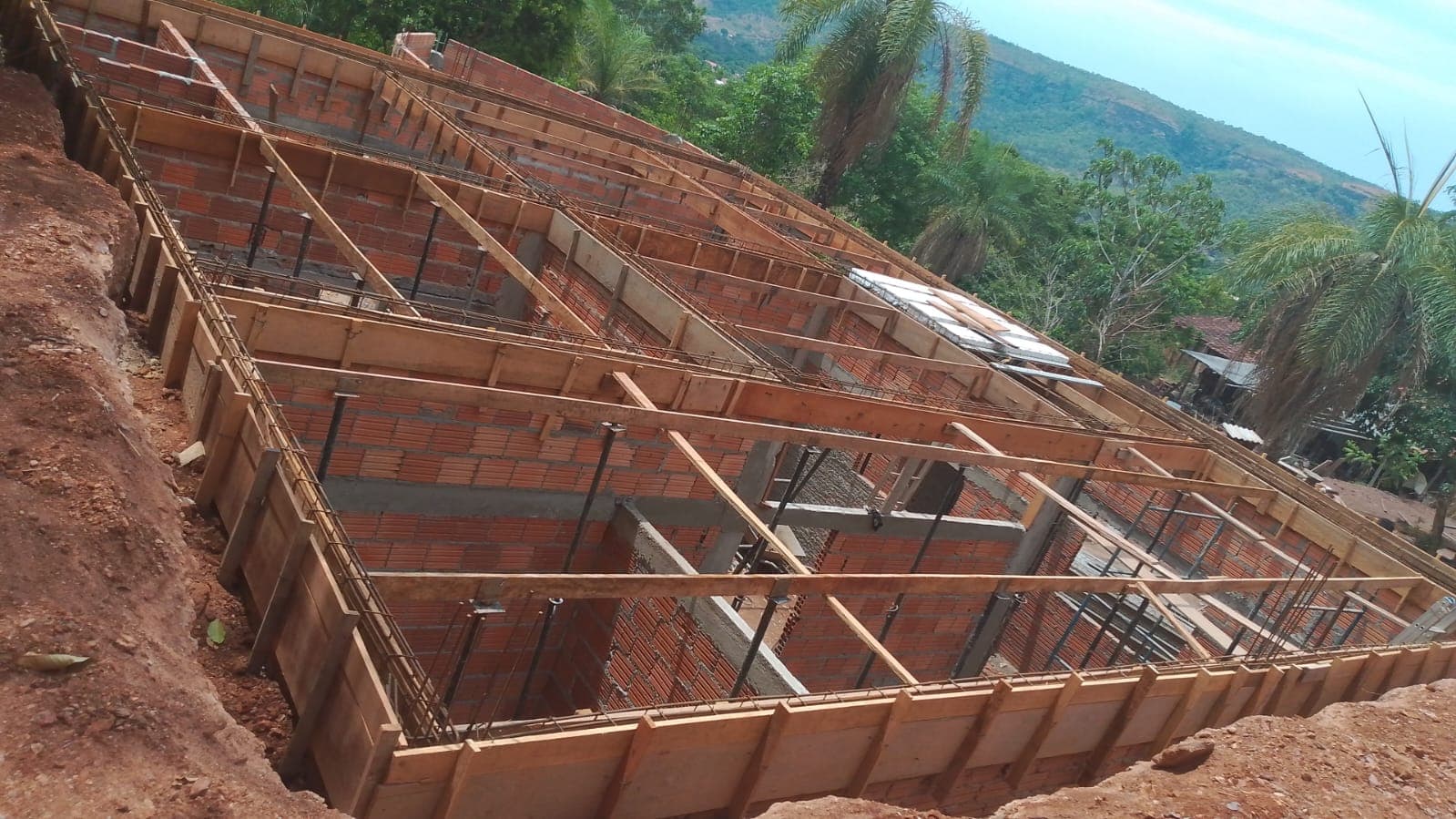 Estrutura da construção com paredes de tijolos, ferragens e formas de madeira para a laje.